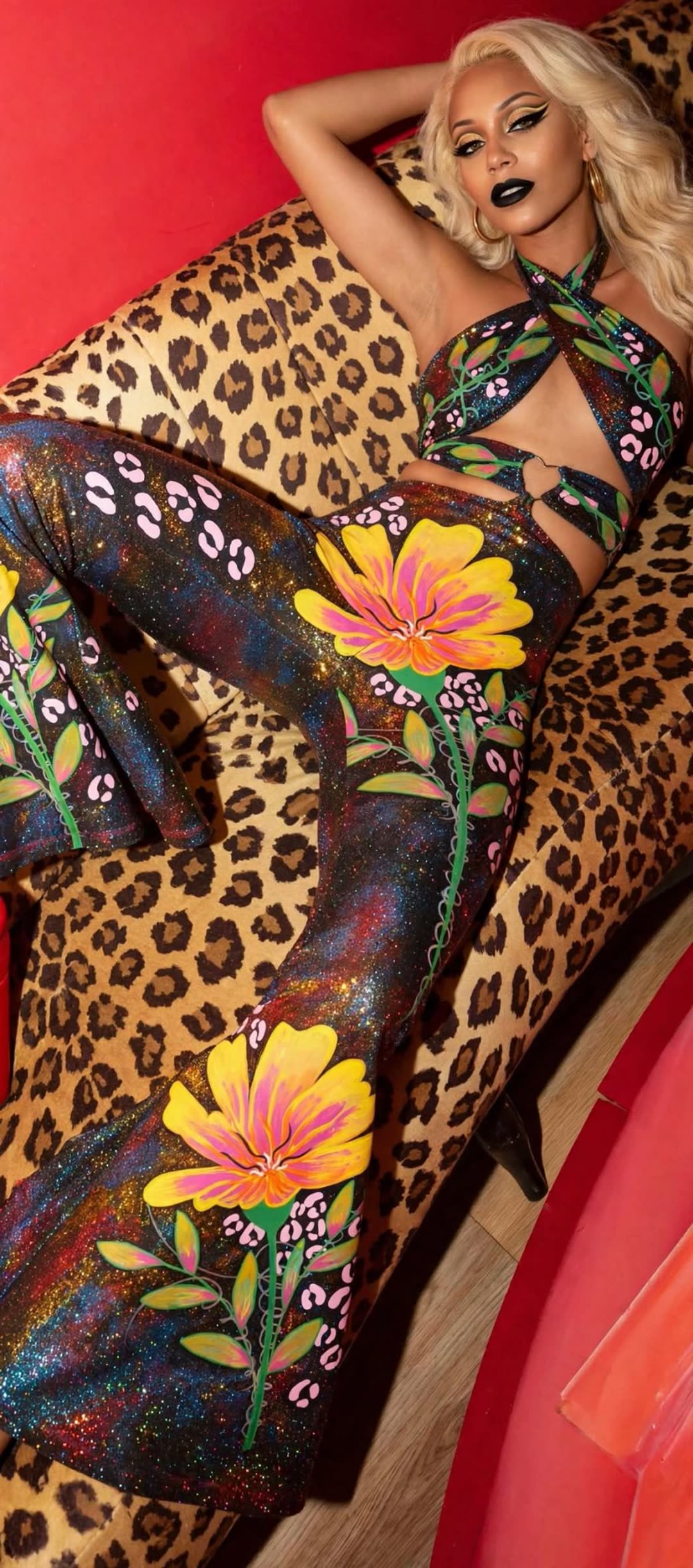 Model wearing the Cosmic Yellow Flower outfit, a halter top and flared pants carrying the golden cosmic bloom design